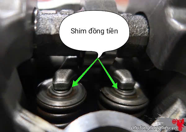 Close-up of valve shims, labeled 'Shim đồng tiền', needing motorcycle valve adjustment on a Winner.